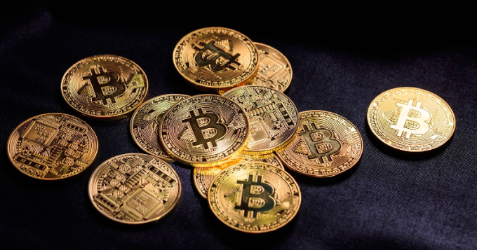 A bunch of gold coins with the bitcoin logo on them