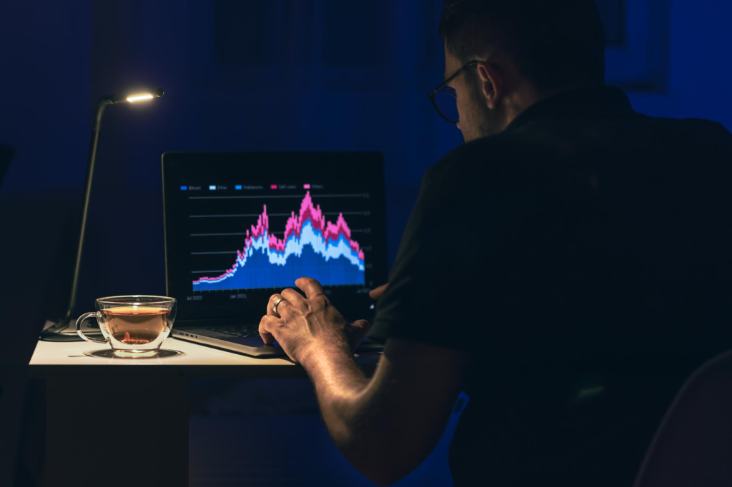 Man browsing the markets and managing his crypto investments at night.