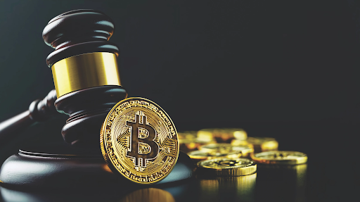 Judge's gavel resting beside a gold Bitcoin coin, with several additional coins blurred in the background against a dark backdrop.