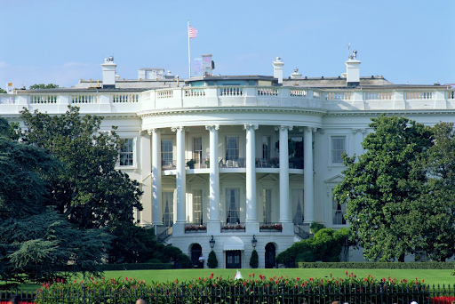Front view of the White House in Washington, D.C.with the American flag flying above the building.