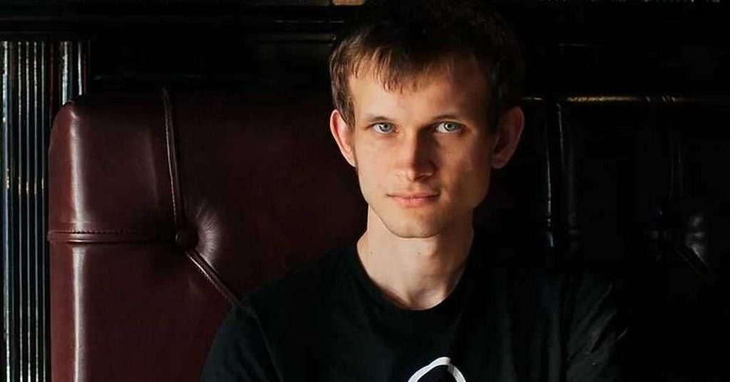 Image of Vitalik Buterin wearing a black shirt and sitting on brown leather chair
