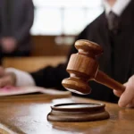 Delio CEO Sentenced to 15 Years in Prison on Crypto Fraud in South Korea A judge holding a wooden gavel over its base in a courtroom, with legal documents on the table.